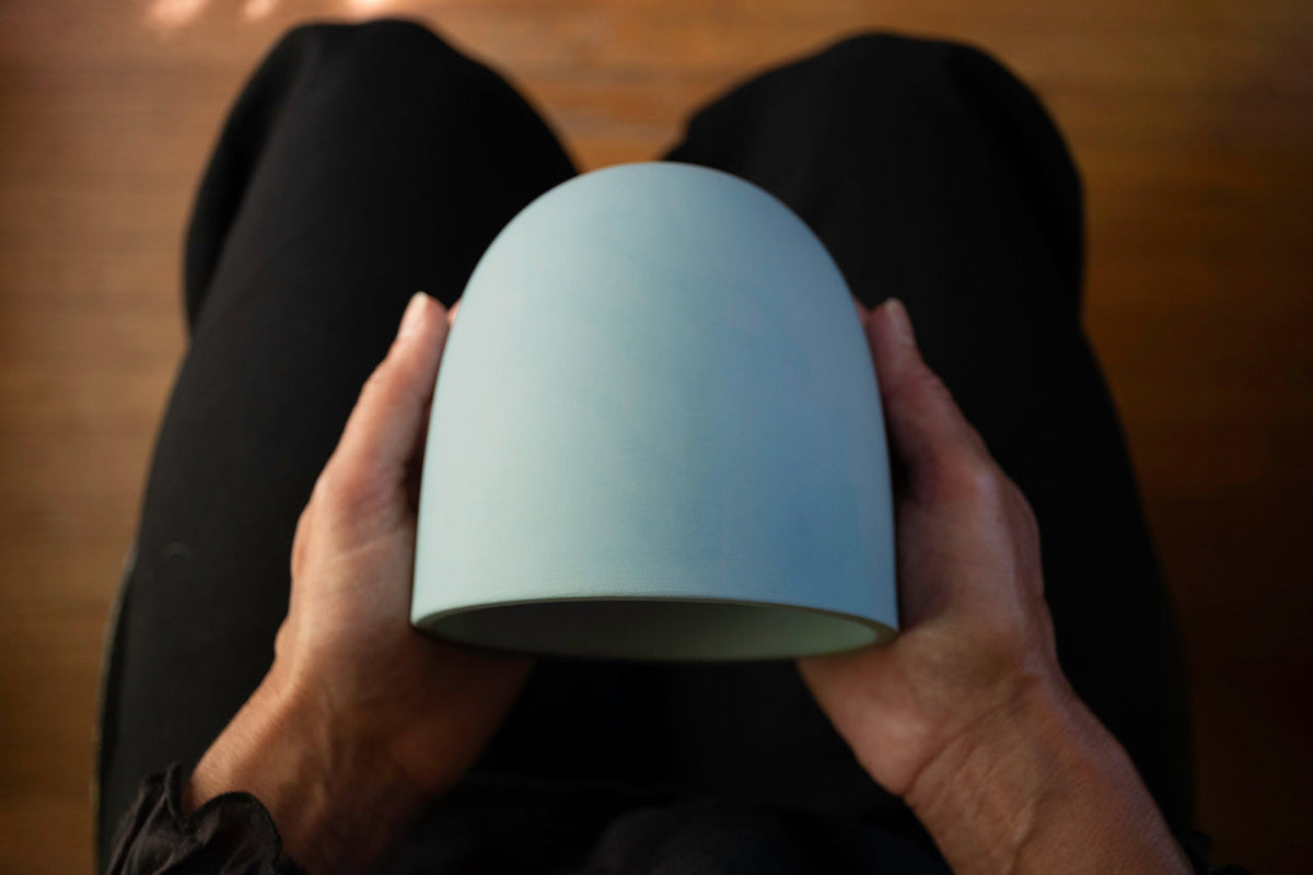 Hands holding a light blue porcelain Cricket wind chime