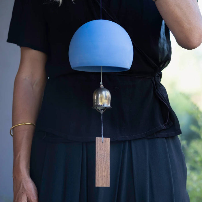 Laela holding a Cairn wind chime in delphinium